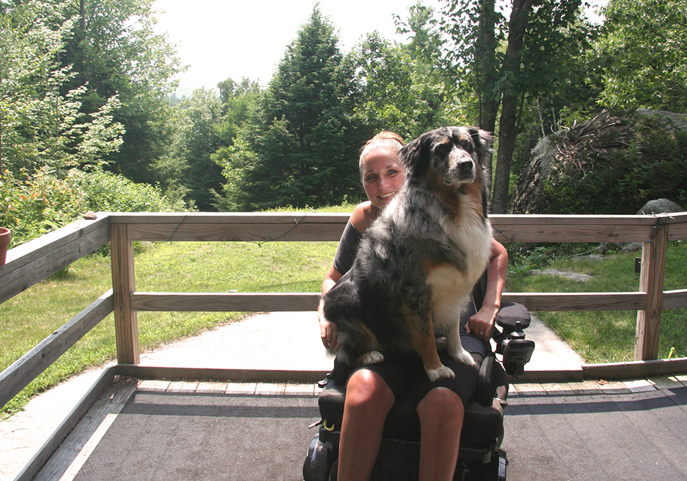 woman in wheelchair with dog on lap